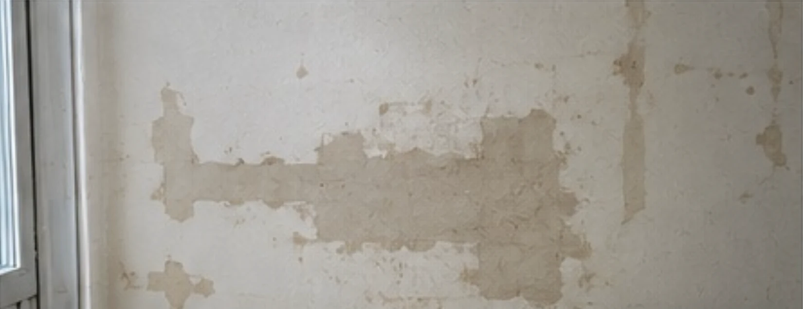 Ancienne réparation et reprise localisée de peinture sur un mur, indice d'antériorité recherché lors d'une expertise vice caché