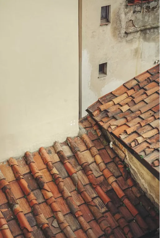 Raccord de toiture en tuiles contre un mur maçonné, point singulier sensible aux infiltrations